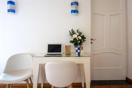 a white desk with a laptop and two white chairs at Suite Lidia B&B in Sorrento