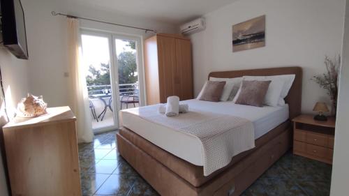 a bedroom with a large bed and a balcony at APARTMAN SUNCE in Baška Voda