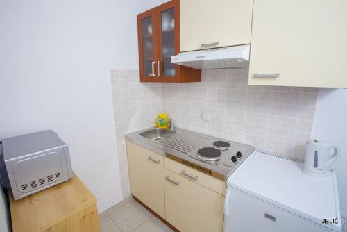 a small kitchen with a stove and a sink at APARTMAN SUNCE in Baška Voda