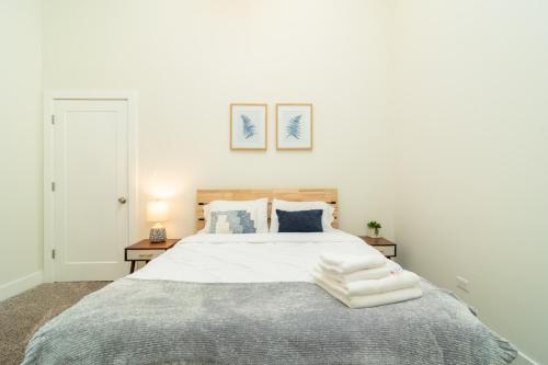 a white bedroom with a large bed with towels on it at McCormick Place 420 friendly 3br-2ba in Downtown Chicago with optional parking for 8 guests in Chicago