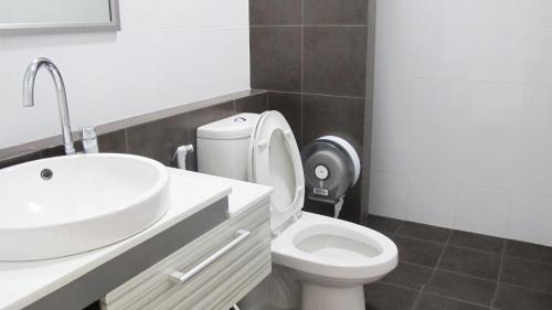 a bathroom with a white toilet and a sink at SLEEPY-Homey Don Mueang Airport Hostel in Bangkok