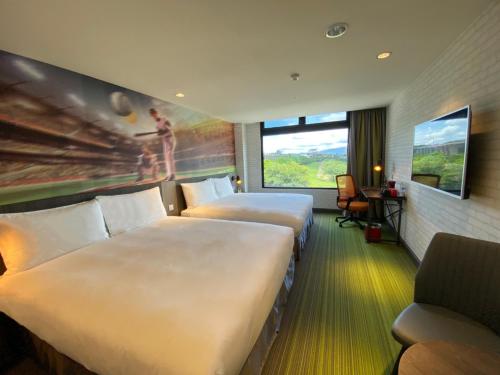 a hotel room with two beds and a window at T11、T12 Hotel in Houli