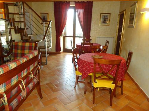 uma sala de jantar com uma mesa e cadeiras e uma escadaria em La Dimora di d'Annunzio em Scanno