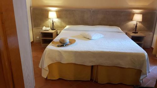 a bedroom with a bed with a hat and a plate on it at Hotel Gallo Nero in SantʼAndrea