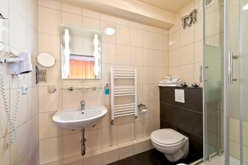 a bathroom with a sink and a toilet at Atlas Berlin Hotel in Berlin