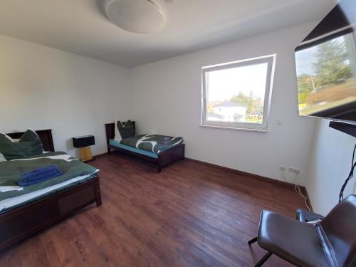 a room with a bed and a couch and a window at Ferienwohnungen Im Grund 22, 22a, 22c Birkenstein in Hoppegarten