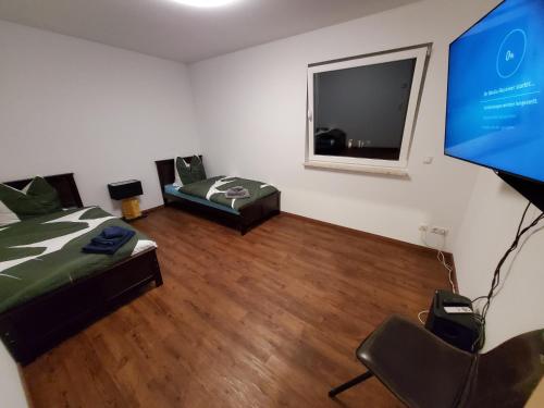 a room with two beds and a flat screen tv at Ferienwohnungen Im Grund 22, 22a, 22c Birkenstein in Hoppegarten