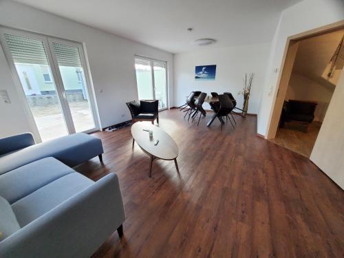 a living room with a couch and a table and chairs at Ferienwohnungen Im Grund 22, 22a, 22c Birkenstein in Hoppegarten
