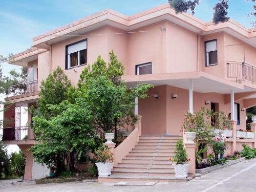 une maison rose avec des arbres devant elle dans l'établissement Apartment Arancio di Liguria - PGI211 by Interhome, à Civezza
