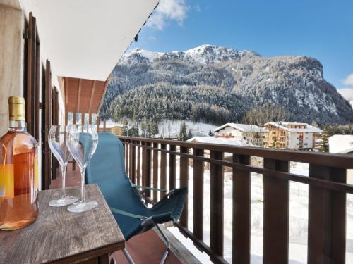 a table with wine glasses on a balcony with a mountain at Apartment Al Parco-1 by Interhome in Canazei