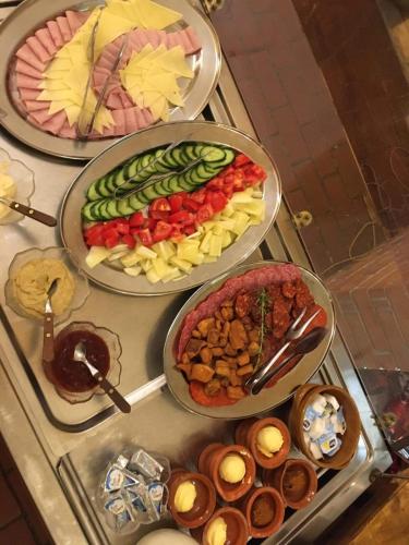 a buffet with three trays of food on a table at Aranykorona Hotel in Miskolc