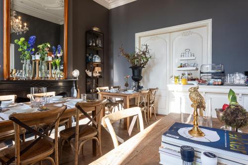 B&B Parijs aan de Kaai في ميدلبورغ: غرفة طعام مع طاولات وكراسي وكاونتر