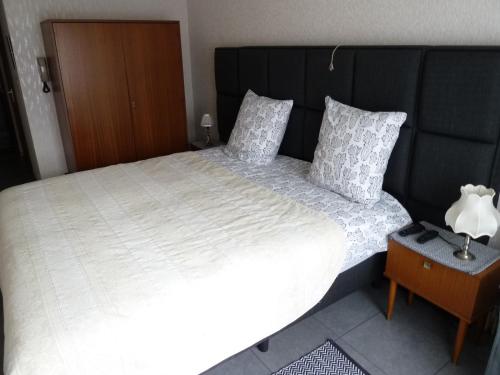 a bed with a white comforter and pillows at DODO DES ILES in Koksijde