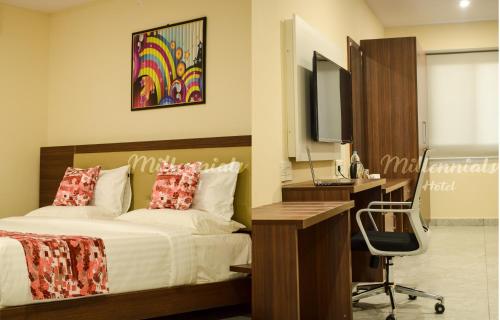 um quarto com uma cama, uma secretária e um computador em PPH Living Millennials Jigani em Bangalore