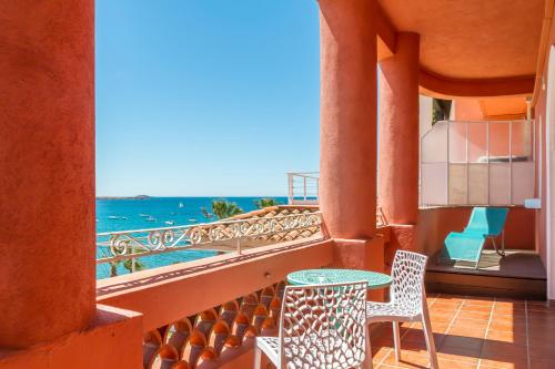 a balcony with a table and chairs and the ocean at Les Galets Hôtel et B&B in Bandol