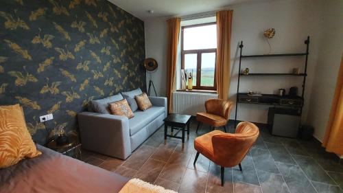 a living room with a couch and a chair at Tisza White House in Tiszaszőlős