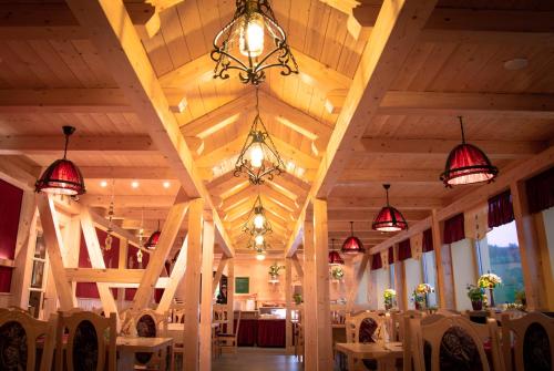 a dining room with wooden ceilings and chandeliers at Ferienhotel Goldhübel in Neuhausen