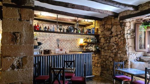 een bar in een stenen kamer met stoelen en een tafel bij Palacete Maria Rosa in Baños de la Encina