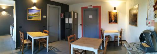 a restaurant with two tables and chairs and a refrigerator at B&B e Ostello, Parco di Monza, CASCINA COSTA ALTA in Monza