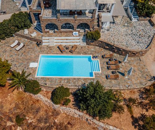 an overhead view of a swimming pool with chaise lounges at Terra in Parikia