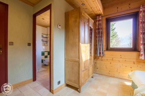 a large room with a large window and a bathroom at Le Bois des Louison in Seytroux