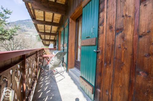 - un balcon d'une maison avec une porte bleue dans l'établissement Le Bois des Louison, à Seytroux