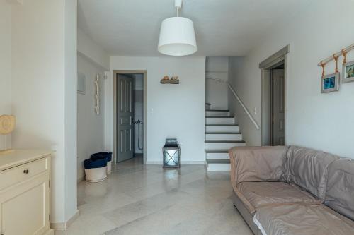 a living room with a couch and a staircase at Terra in Parikia