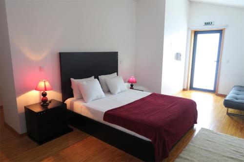 a bedroom with a bed and a chair and two lamps at Quinta Lama de Cima in Fafe