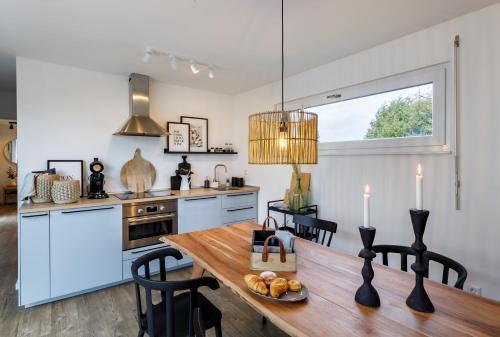 a kitchen with a wooden table with chairs and a dining room at Tiny Cubus in Osterhofen