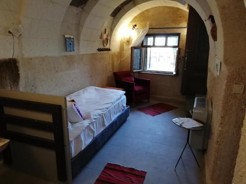 a small room with a bed and a window at Pigeon Hotel Cappadocia in Uchisar