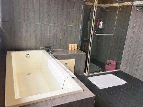 a bathroom with a white tub and a shower at CountrySide B&B in Zhuangwei