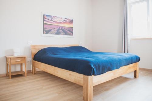 1 dormitorio con cama de madera y manta azul en Agriturismo Il Capitolo, en Carpaneto Piacentino