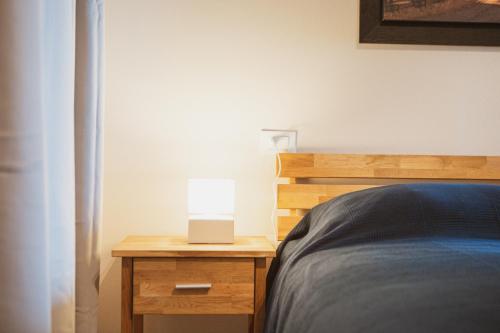 a bed with a lamp on a wooden night stand at Agriturismo Il Capitolo in Carpaneto Piacentino