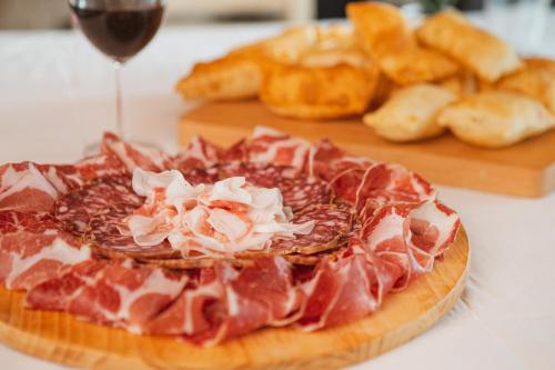 a pizza on a table with a glass of wine and bread at Agriturismo Il Capitolo in Carpaneto Piacentino