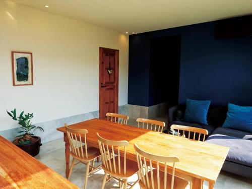 a dining room with a table and chairs and a couch at CHULAX OKINAWA YOMITAN【Designer Condominium Hotel】 in Yomitan