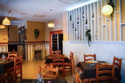 クリェラにあるHotel L'Escalaのテーブルと椅子、暖炉のあるレストラン
