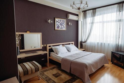 a bedroom with a large bed and a mirror at Fakel Hotel in Orenburg
