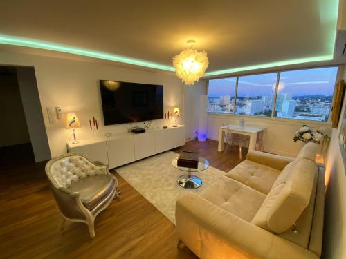 Una sala de estar con un sofá y un televisor. en la Goelette, en Toulon