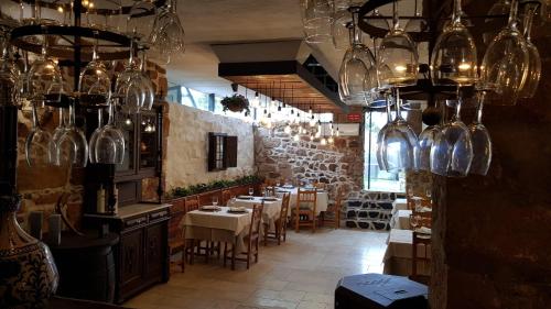 a restaurant with tables and chairs and glass vases at Palacete Maria Rosa in Baños de la Encina