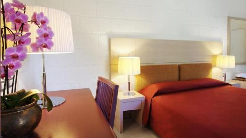 a bedroom with a bed and a table with a plant at Tenuta Monacelle in Selva di Fasano