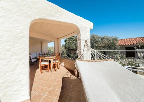 a balcony of a house with a table and chairs at Fronte Mare Premium in Agrustos