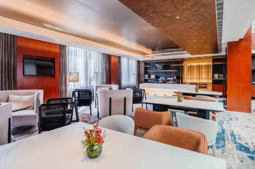 a room with tables and chairs and a kitchen at Marco Polo Jin Jiang in Jinjiang