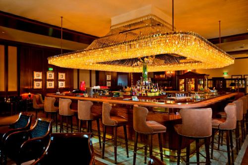 a bar in a restaurant with a large chandelier at InterContinental Wien, an IHG Hotel in Vienna