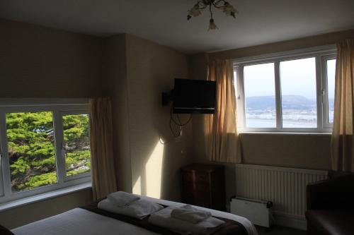 スランディドノにあるHeadlands Hotelのベッドルーム1室(窓2つ、ベッド1台、タオル付)
