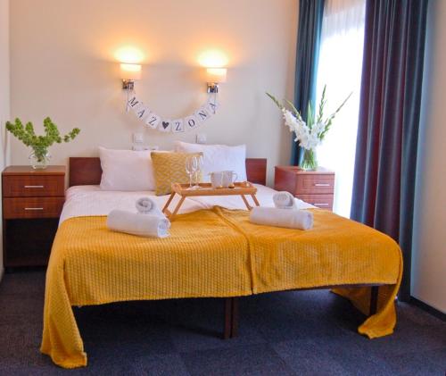 a bedroom with a bed with two towels on it at Hotel Przy Solankach in Grudziądz