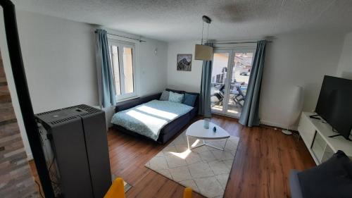 Appartement Le 18 في Ependes: غرفة معيشة فيها سرير وتلفزيون