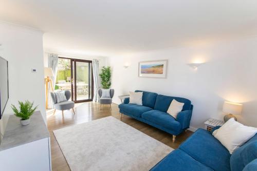a living room with a blue couch and a table at Rockpool - Attractive and spacious retreat near Croyde beach - Sleeps 8 in Croyde