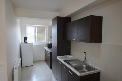 a small kitchen with a sink and a refrigerator at Tuya Residence in Eforie Nord