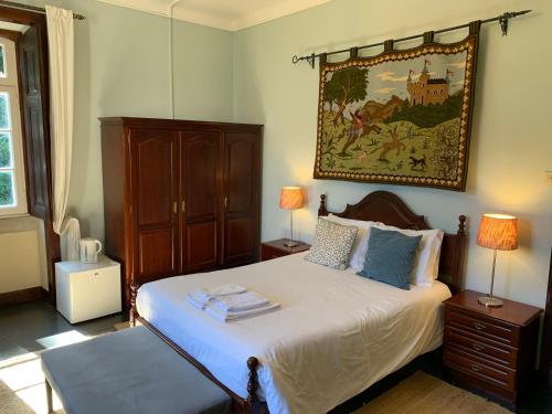 a bedroom with a bed and a painting on the wall at Chalet Relogio Guesthouse in Sintra