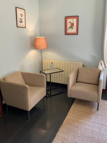 a living room with two chairs and a table at Chalet Relogio Guesthouse in Sintra